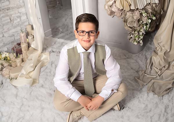 Niño de comunión sentado en el suelo