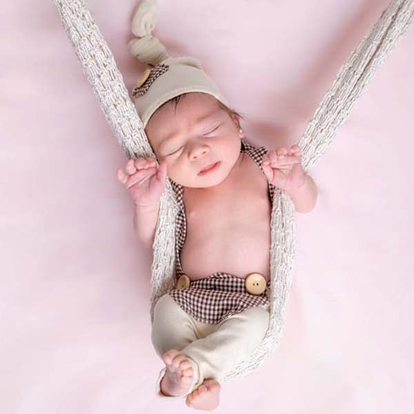 Bebé newborn durmiendo en columpio